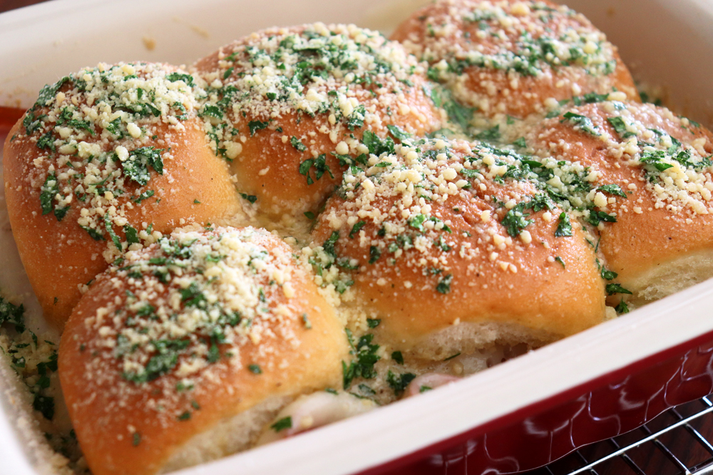 Sprinkling the top of the rolls with parmesan and parsley