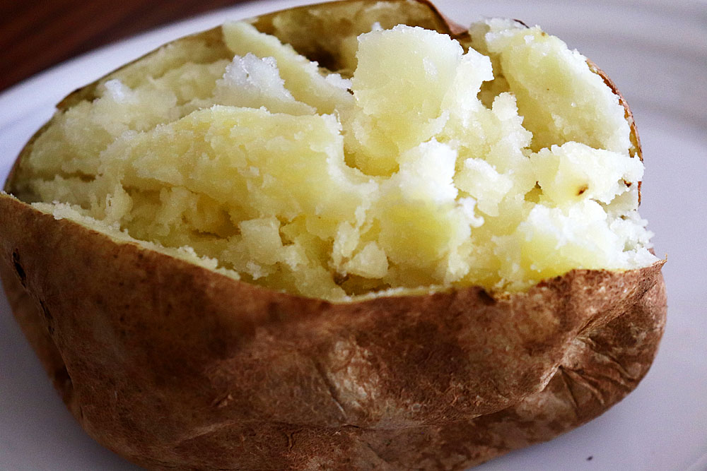 Slice and squeeze the baked potato to make room for the filling