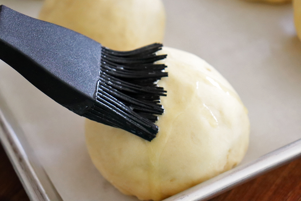 Brushing the dough balls with butter